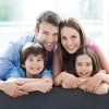 Lächelnde vierköpfige Familie auf dem Sofa