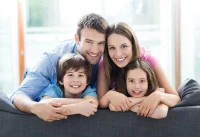 Lächelnde vierköpfige Familie auf dem Sofa